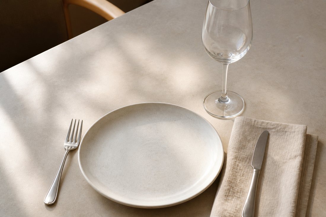 Mesa posta de restaurante vista de cima, com prato e taça vazios
